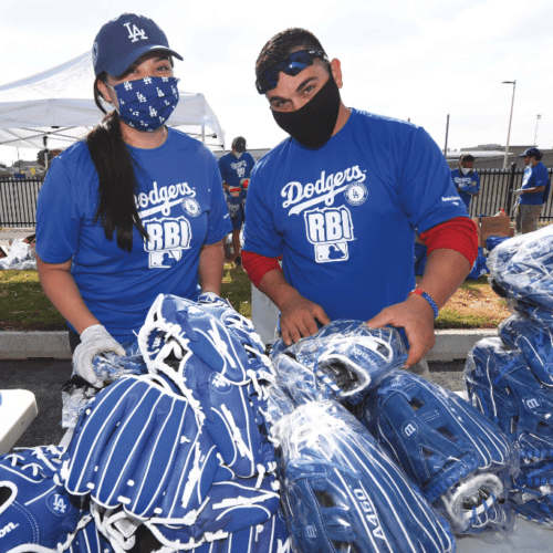 Volunteers with Masons4Mitts hand out baseball gloves as part of the Masonic charity drive