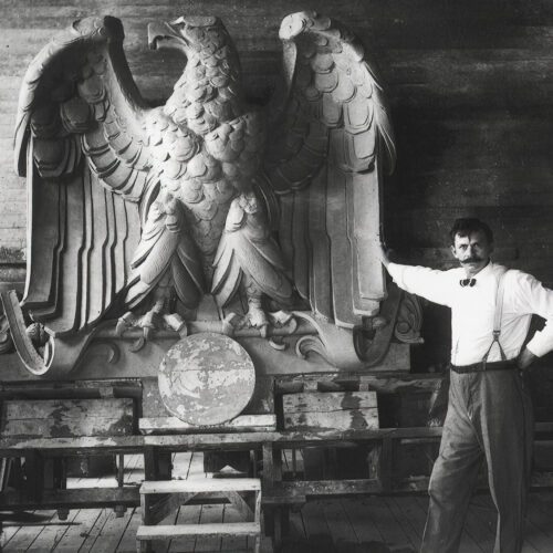 A worker poses with a giant, terra-cotta eagle figure. One of California's most famous art forms and a key part of the arts and crafts movement, terra cotta tile were championed by two important California Masons.