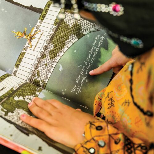 A child reads a book given to her by Raising a Reader, a children's literacy nonprofit. Thanks to the Masons of California, Raising a Reader has expanded its childhood literacy program into 1,000 California public school classrooms.